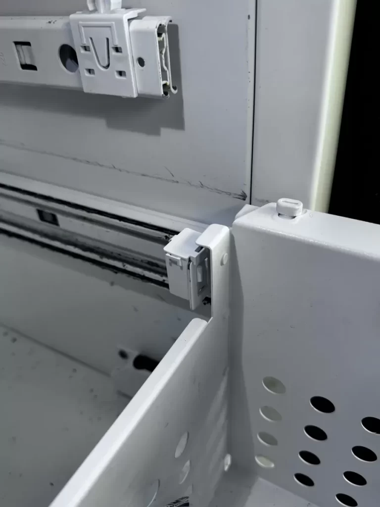 Support clip seated at the end of the freezer slide rail beside the basket in a Thermador fridge