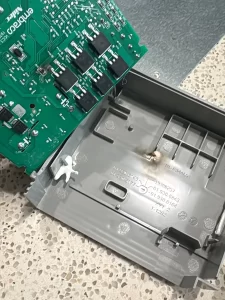 Old Thermador fridge inverter board lifted out of its housing, with a scorch mark inside the plastic cover, Surrey, BC